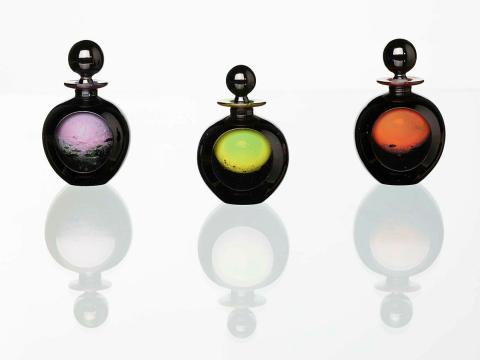 Artwork Set of three perfume bottles this artwork made of Hot-worked green, red and yellow glass cased clear and black with one wheel cut facet, created in 1988-01-01