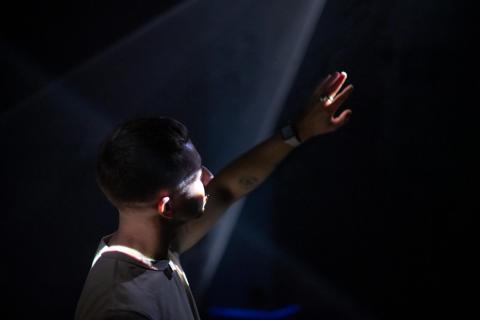 An installation view of a visitor exploring a work made of light.