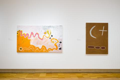 Two paintings installed on a white wall in a gallery space