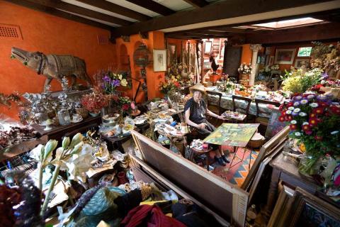 A saturated photograph of Margaret Olley in her colourful, cluttered studio.