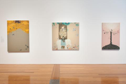 Three Mongol zurag paintings installed on a white wall in a bright gallery space
