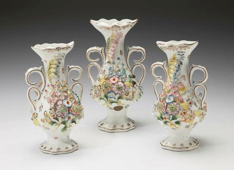 Artwork Three piece garniture this artwork made of Porcelain (bone china), swelling body with flared lip, double scroll handles, modelled on both sides with a bouquet of flowers painted in polychrome overglaze enamels. Gilt details, created in 1840-01-01