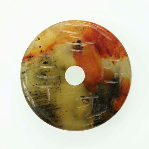 Artwork Pi:  (disk) this artwork made of Black, brown and green jade, carved and incised