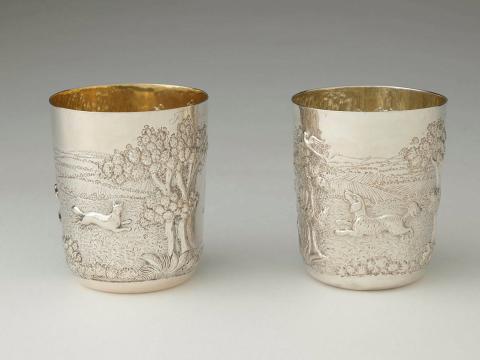 Artwork Pair of stirrup cups this artwork made of Silver, repousse and stipple decorated with a landscape hunting scene depicting dogs, fox, pheasants etc., created in 1819-01-01