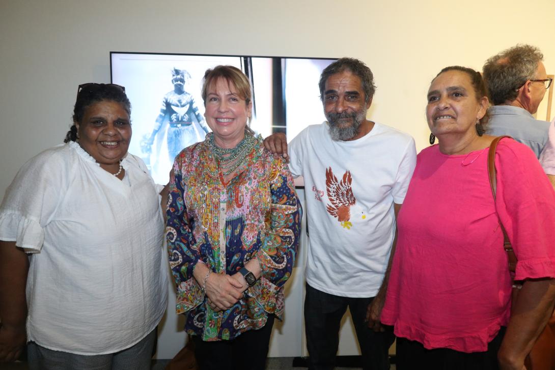 A group of people stand smiling in a gallery space