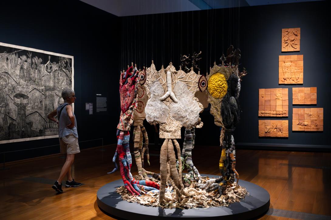 An installation view of works by Nepalese artists in a dimmed gallery space