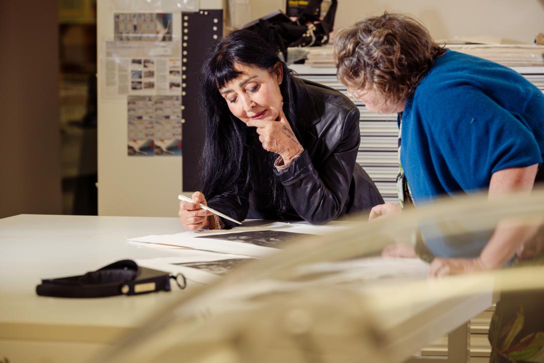 In the background of this photograph taken in the QAG Conservation Lab, artist Pat Hoffie and Samantha Shellard (Works on Paper Conservator, QAGOMA) review a portfolio box of prints
