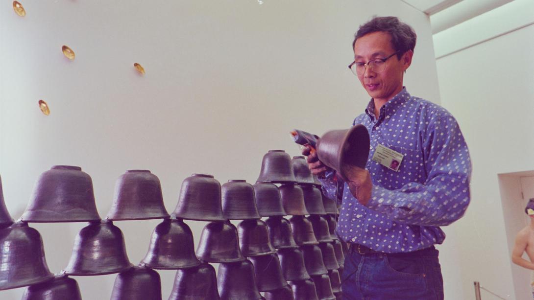 An artist installs an installation made from ceramic bells