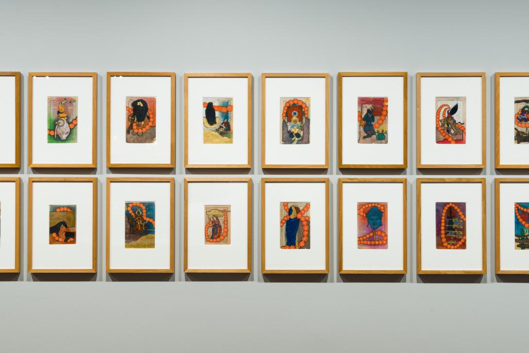 A detail view of miniature works on paper installed on a gallery space