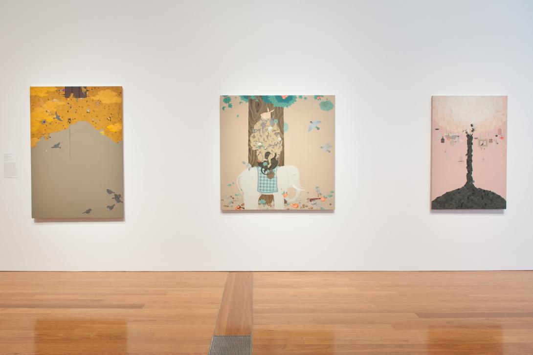 Three Mongol zurag paintings installed on a white wall in a bright gallery space