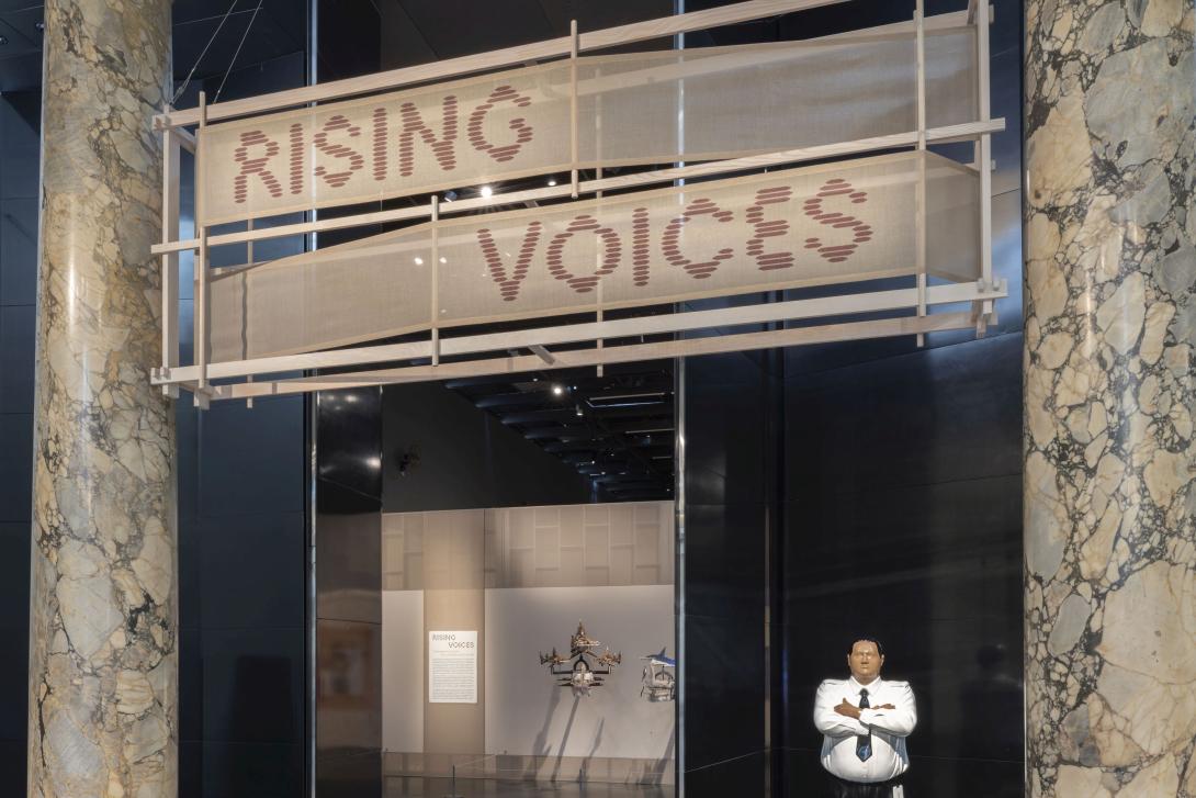 'Rising Voices' at the Victoria and Albert (V&A) Museum, London, May 2025, guarded by Michael Parekōwhai's Kapa Haka (Whero) 2003, and with glimpses of headdresses by Ken Thaiday Snr / © The artists / Image courtesy and © The V&A, South Kensington