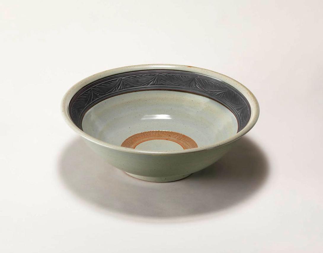 Artwork Celadon bowl this artwork made of Stoneware, thrown with interior chattered firing rim and iron slip stained carved foliate band.  Celadon glaze, created in 1980-01-01