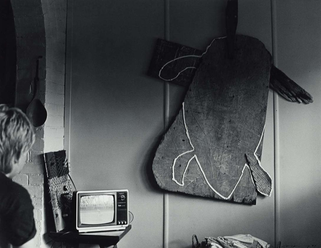 Artwork 14 January 1987, Atherton - Tom Risley had hung a sculpture on his wall. His son Jeff watched test cricket on T.V. (from 'Journeys north' portfolio) this artwork made of Gelatin silver photograph on paper, created in 1987-01-01