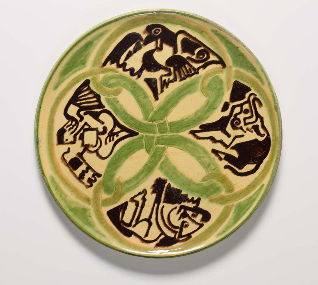 Artwork (Plate with Celtic motifs and figures representing the four beasts from Revelation 4) this artwork made of Wheel-thrown and incised earthenware with slip decoration, and green, cream and brown-black glazes, created in 1948-01-01