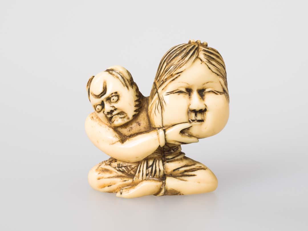 Artwork Netsuke: (Oni holding Otafuku mask) this artwork made of Carved ivory, created in 1800-01-01