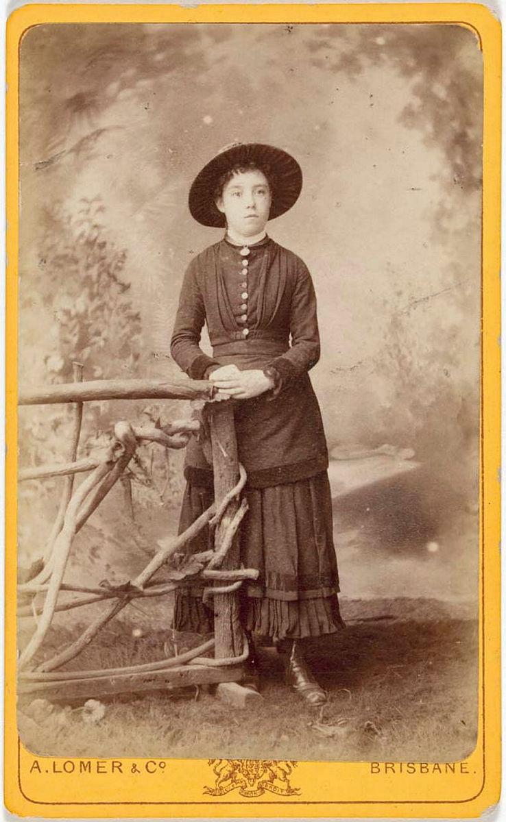 Artwork (Young lady standing beside wooden fence) this artwork made of Albumen photograph on paper mounted on card, created in 1874-01-01