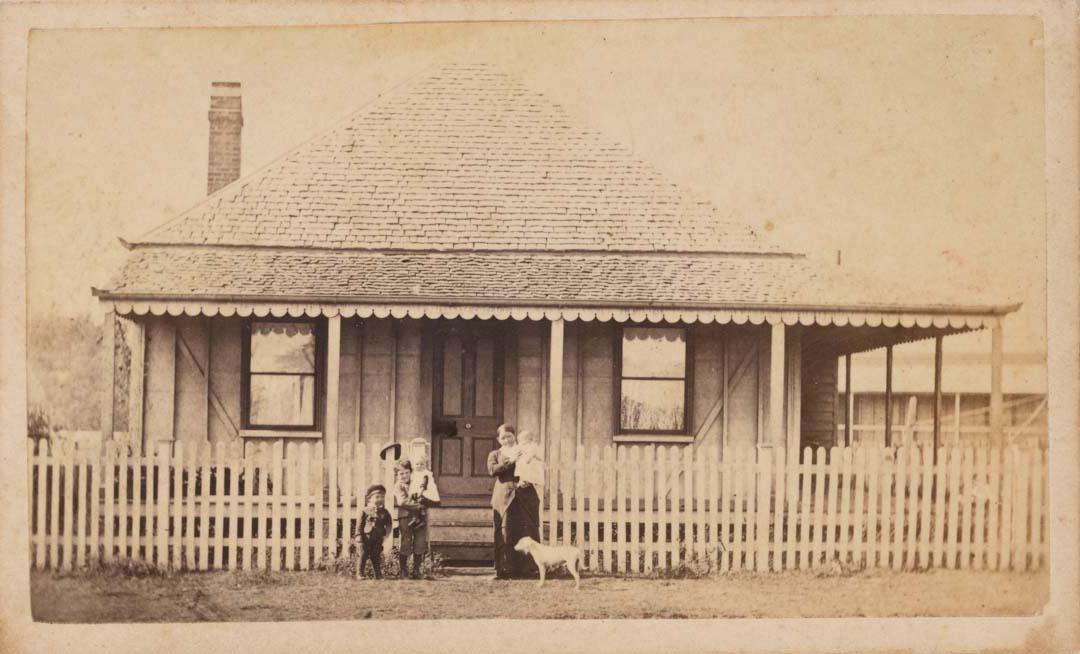 Artwork (Woman, baby, three children and dog in front of Brisbane shingle-roofed house) this artwork made of Albumen photograph on paper mounted on card