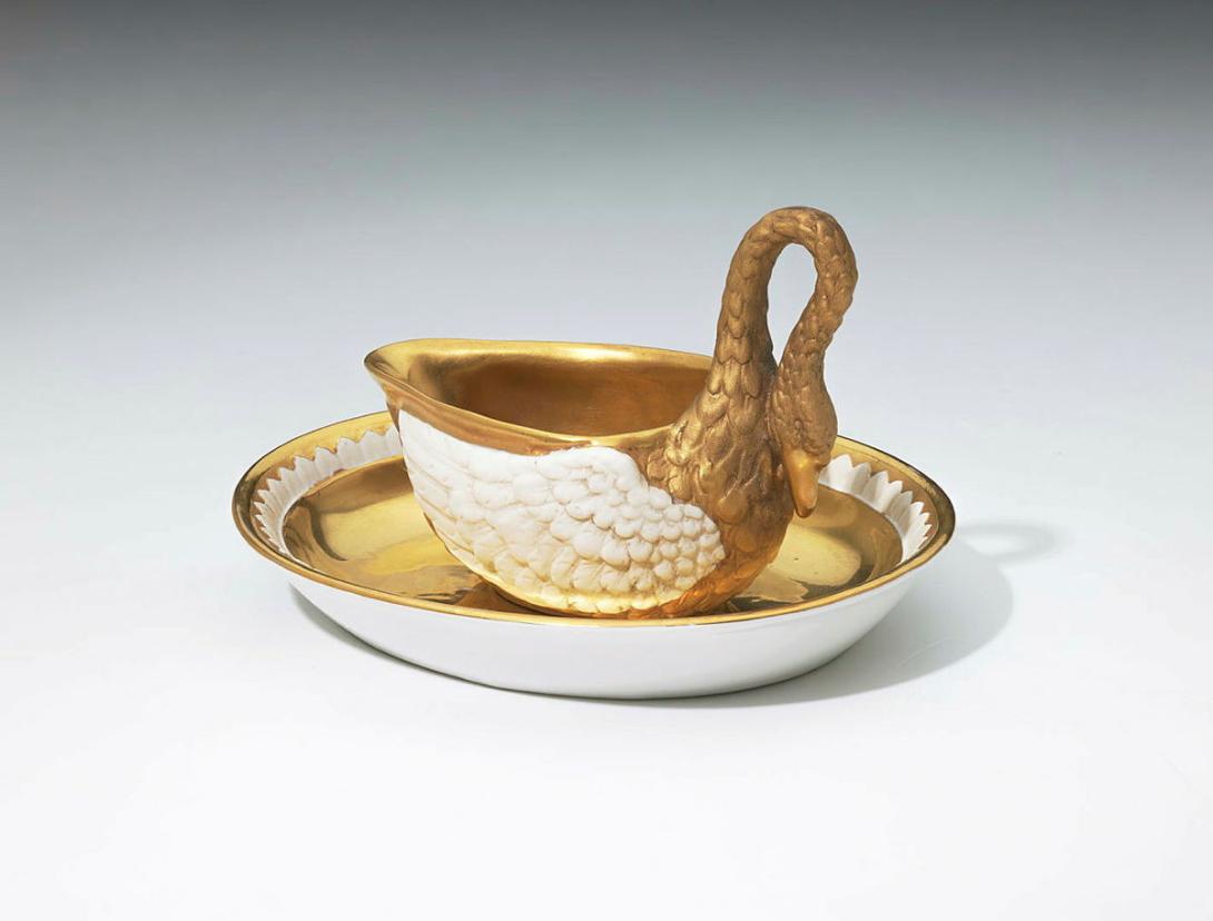 Artwork Swan cup and saucer this artwork made of Hard-paste porcelain cup modelled in the form of a swan entirely gilt except for the wings.  The oval saucer gilt except for a white 'feather' border, created in 1804-01-01