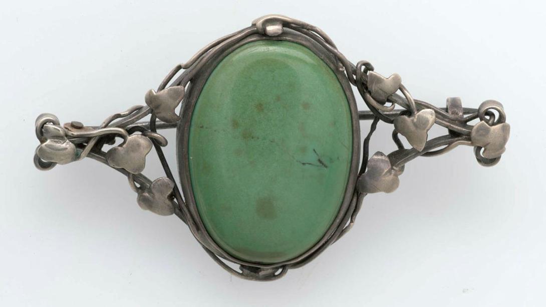 Artwork Brooch this artwork made of Handwrought silver with ivy leaves and tendrils in the arts and crafts manner framing a turquoise stone, created in 1940-01-01