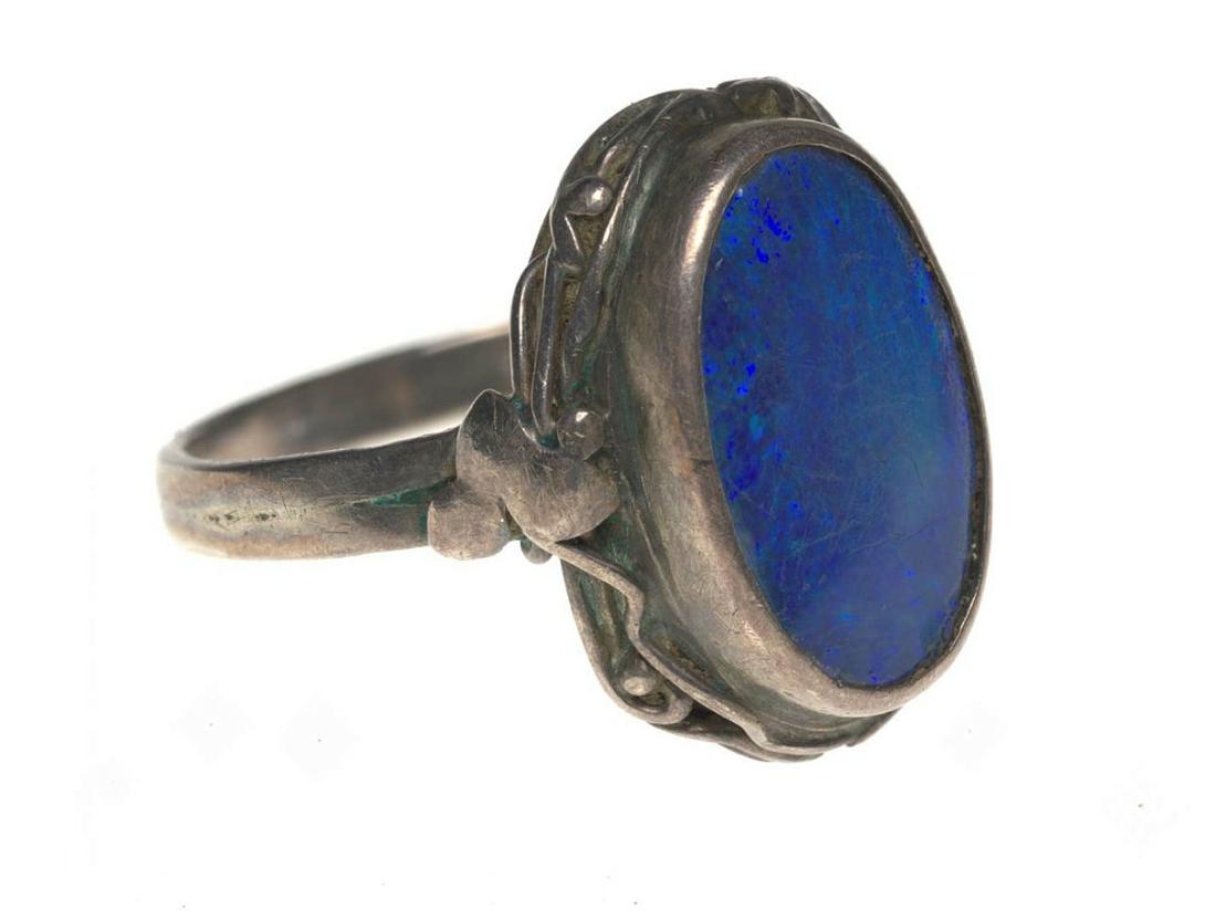Artwork Ring this artwork made of Highset oval blue opal framed with tendrils of silver with single ivy leaves at the shoulder in the arts and crafts manner, created in 1940-01-01