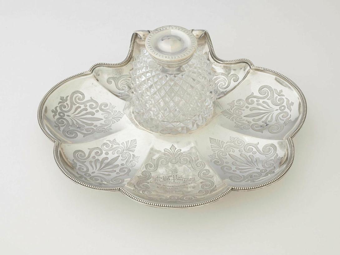 Artwork Inkstand this artwork made of Silver, pectin shell-shaped base with circular depression for ink-well, engraved with anthemion motifs, created in 1867-01-01