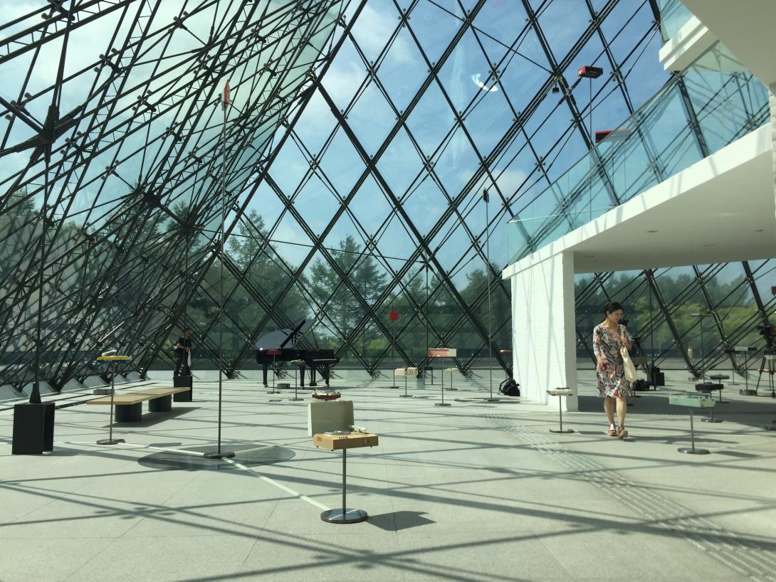 An installation inside a bright gallery space with a glass ceiling.