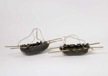 Installation view of two water carriers, made from bull kelp, ti-tree wood skewers and spun plant fibre string.