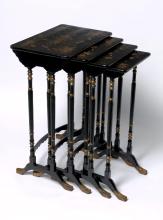A set of four dark timber lacquered tables from the Qing dynasty, with gilded detailing on the legs and hand painted floral designs on the top. The four tables are slightly different sizes and are slotted into each other.