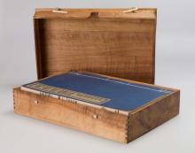 A view of an open wooden box containing two books from Xu Bing's 'A book from the sky' installation.