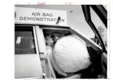 A black and white photograph of an airbag activating in a car.