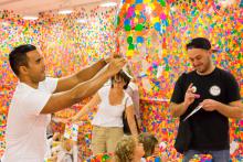 Gallery visitors ‘obliterate’ an installation space with colourful dot stickers for Yayoi Kusama’s The obliteration room.