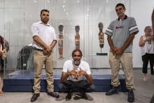 A photograph of three descendants of Fred Embrey with Embrey's sculpture at UQ Anthropology Museum 