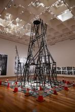 An installation constructed from ladders and traffic cones, installed in the centre of a gallery s[ace