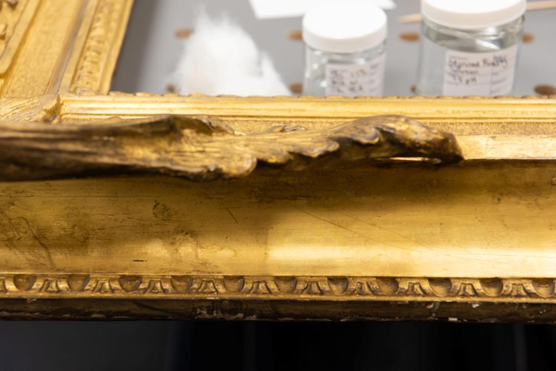 A close-up photo of a section of gilded frame cleaned by QAGOMA's frame conservators.