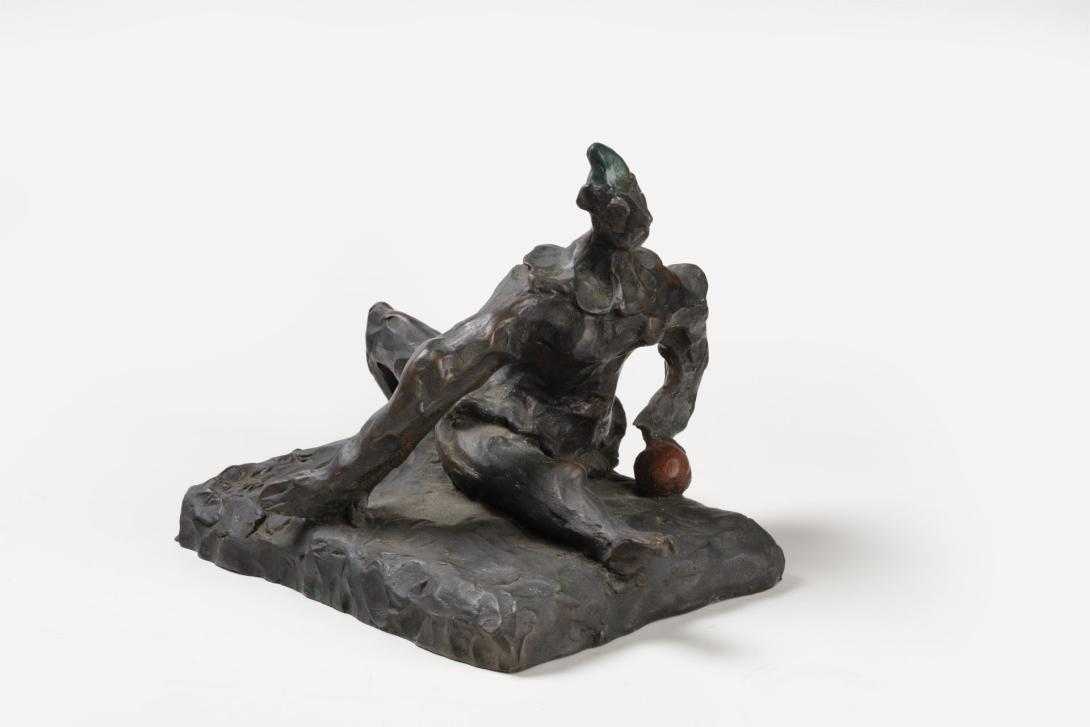 A small bronze sculpture depicts a man doing the splits.