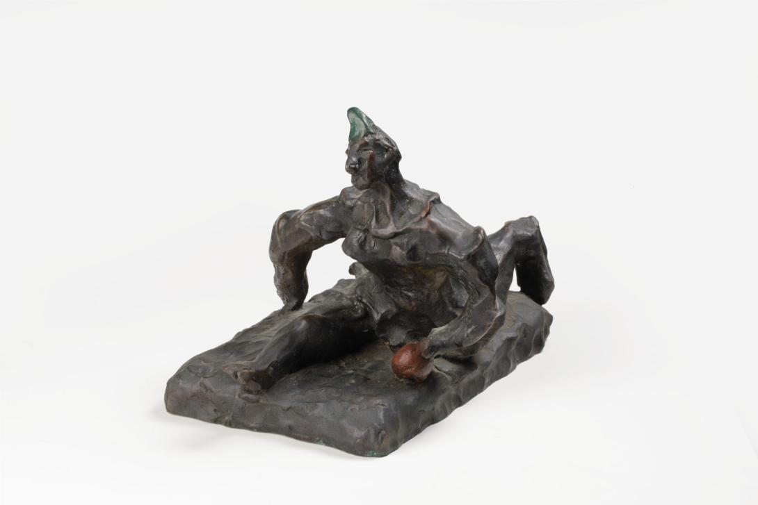 A small bronze sculpture depicts a man doing the splits.