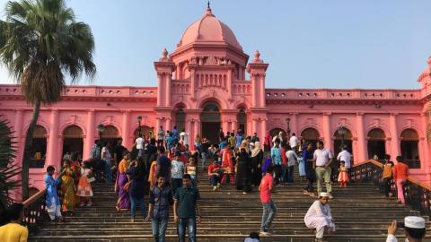 A photograph of crowds outside Ahsan Manzil, a bright pink palace (cropped)