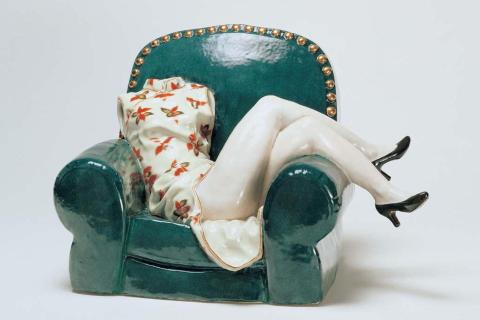 A ceramic sculpture of a headless, armless figure on a green sofa. Liu Jianhua / China b.1962 / Obsessive memories (detail) 2000 / Porcelain, modelled and with overglaze colours, incised / Purchased 2004. Queensland Art Gallery Foundation / © Jianhua Liu