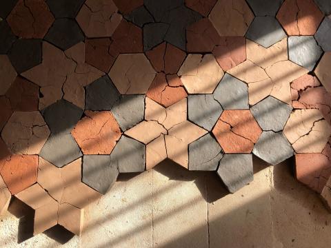 A detail view of an artwork made of adobe bricks in a pattern of geometric shapes