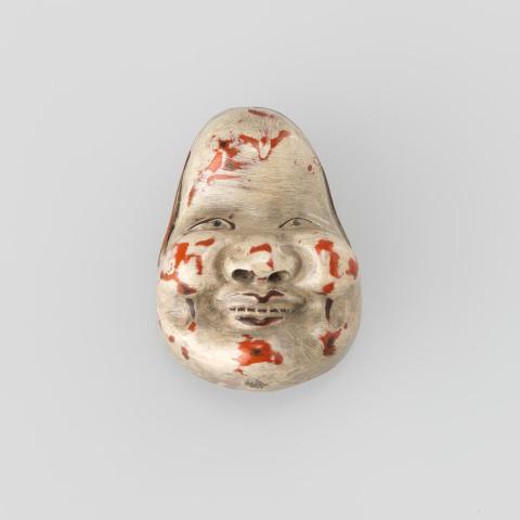Artwork Netsuke:  (mask) this artwork made of Wood with white paint worn through to the red lacquer below, created in 1800-01-01