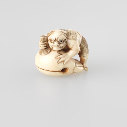 Artwork Netsuke:  (horned demon beating a Buddhist temple gong) this artwork made of Carved ivory with rectangular red lacquer inset in base, created in 1800-01-01