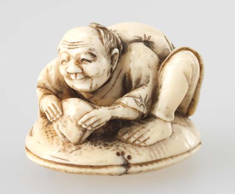 Artwork Netsuke:  (man crouching on a clam shell) this artwork made of Carved ivory, created in 1800-01-01