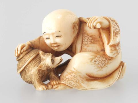 Artwork Netsuke:  (child playing with a puppy) this artwork made of Carved ivory with inset red lacquer, created in 1800-01-01