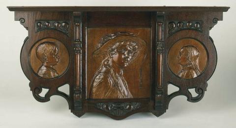 Artwork Wallbracket:  Infancy, Youth and Maturity this artwork made of Beech carved circular panels depicting bust of a baby and an old woman flanking a larger square panel of a young woman in a wide brimmed hat in 3/4 profile. Framed in silky oak with two carved pillars and subsidiary leaf ornament in the art nouveau manner, created in 1910-01-01