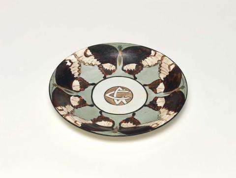 Artwork Plate this artwork made of China painted white earthenware with border of four butterflies in black/brown, white and red against a grey ground enclosing GC (in monogram) black rim
