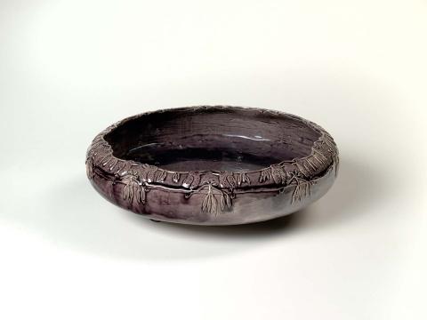 Artwork Kookaburra bowl this artwork made of Earthenware, press-moulded low circular bowl on three small feet.  Carved with a continuous freize of kookaburras and glazed mauve/grey, created in 1924-01-01