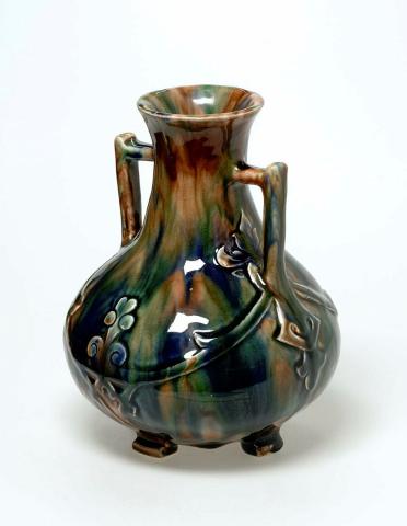 Artwork Long necked vase this artwork made of Earthenware, hand-built bulbous vase with two handles and carved decoration. Glazed brown splashed with colours, created in 1936-01-01