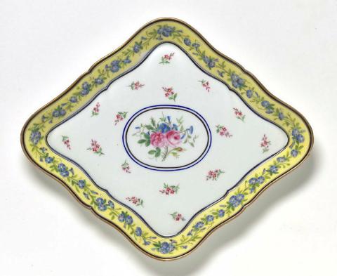 Artwork Pair of lozenge shaped dishes this artwork made of Soft-paste porcelain, lozenge-shaped dishes with a central panel of roses and convolvulus on a field of scattered flowers.  Yellow borders with trailing convolvulus between a black and blue line, created in 1793-01-01
