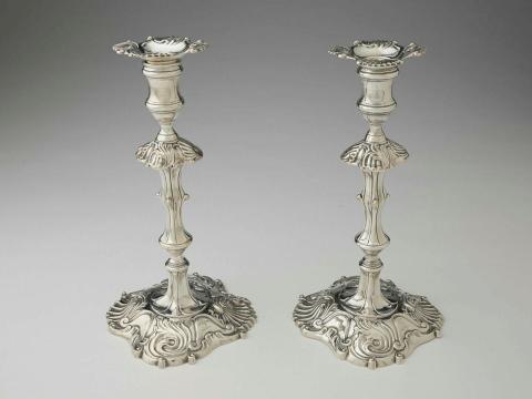 Artwork Candlesticks with drip pans this artwork made of Silver decorated with cast scrolls and shells on the base, knop and drip pan. Engraved with heraldic crest, created in 1751-01-01