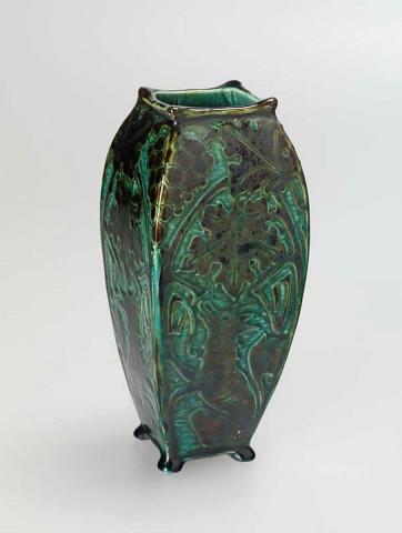 Artwork Vase:  (The fox and the grapes) this artwork made of Slab built white clay body of swelling square profile, dipped brown clay and carved.  Blue-green glaze, created in 1920-01-01